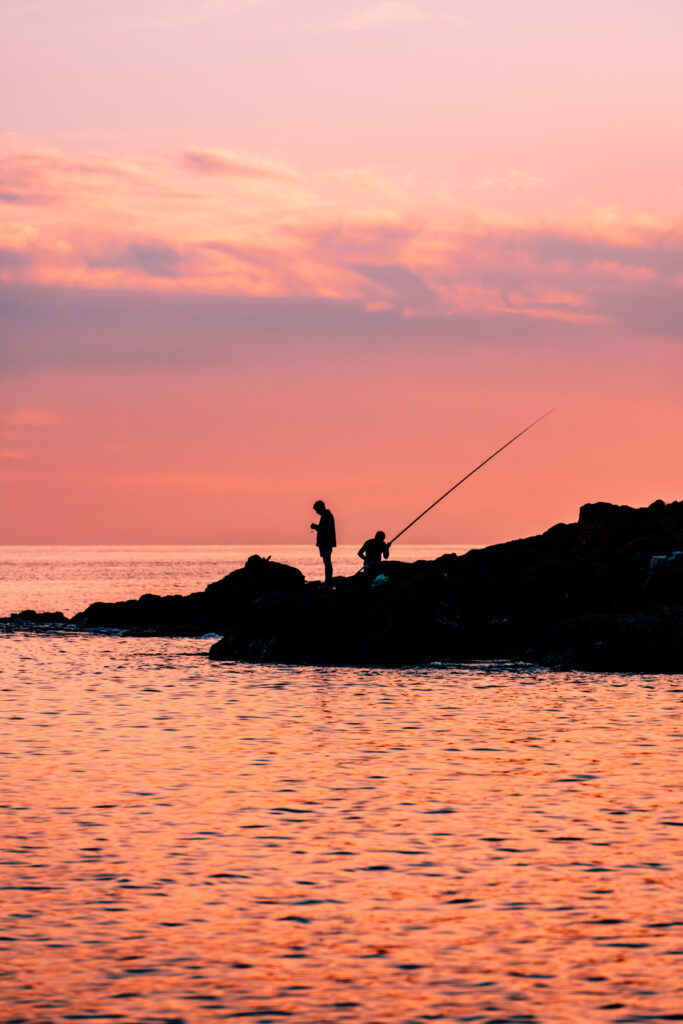 Fisherman silhouettes during sunset