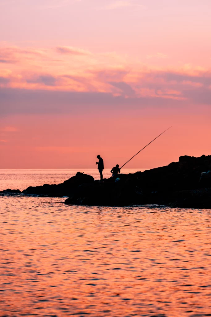 Fisherman silhouettes during sunset